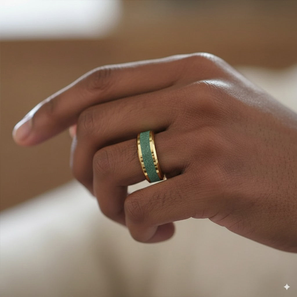 Hand wearing a green and gold ring on a blurred background