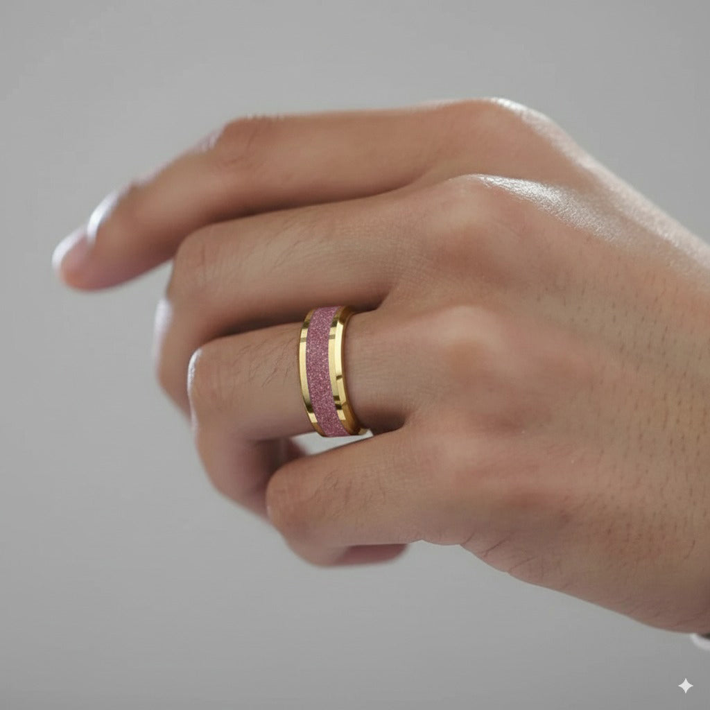 Hand wearing a pink and gold ring on a neutral background